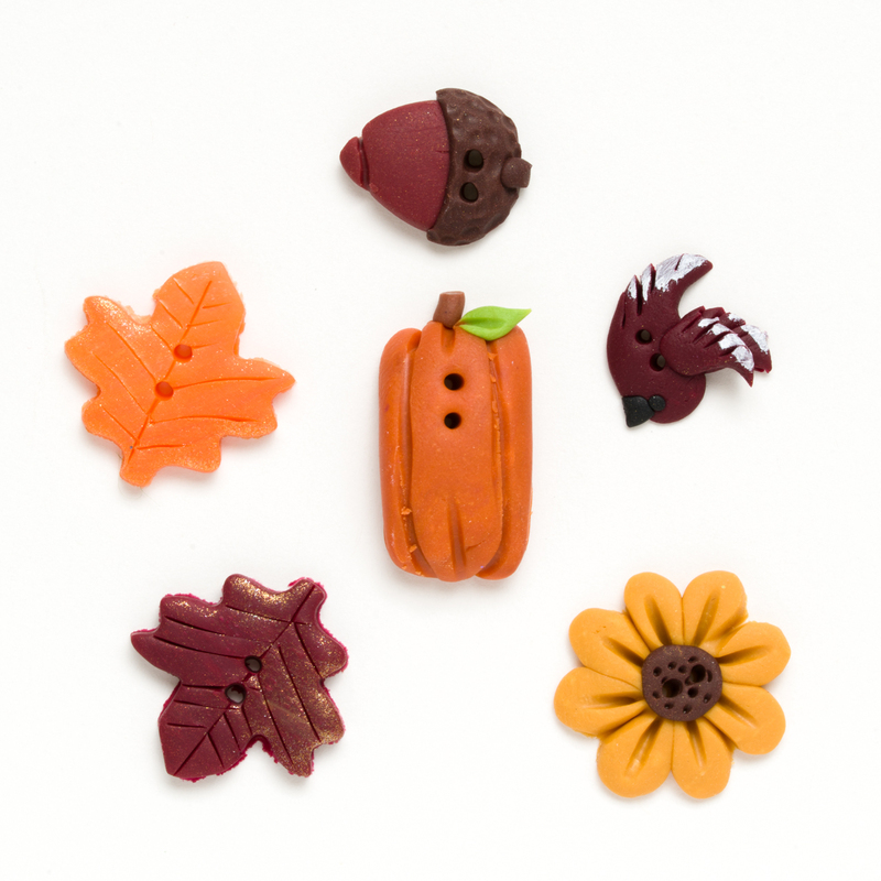 Assorted fall-themed decorative buttons on a white background.