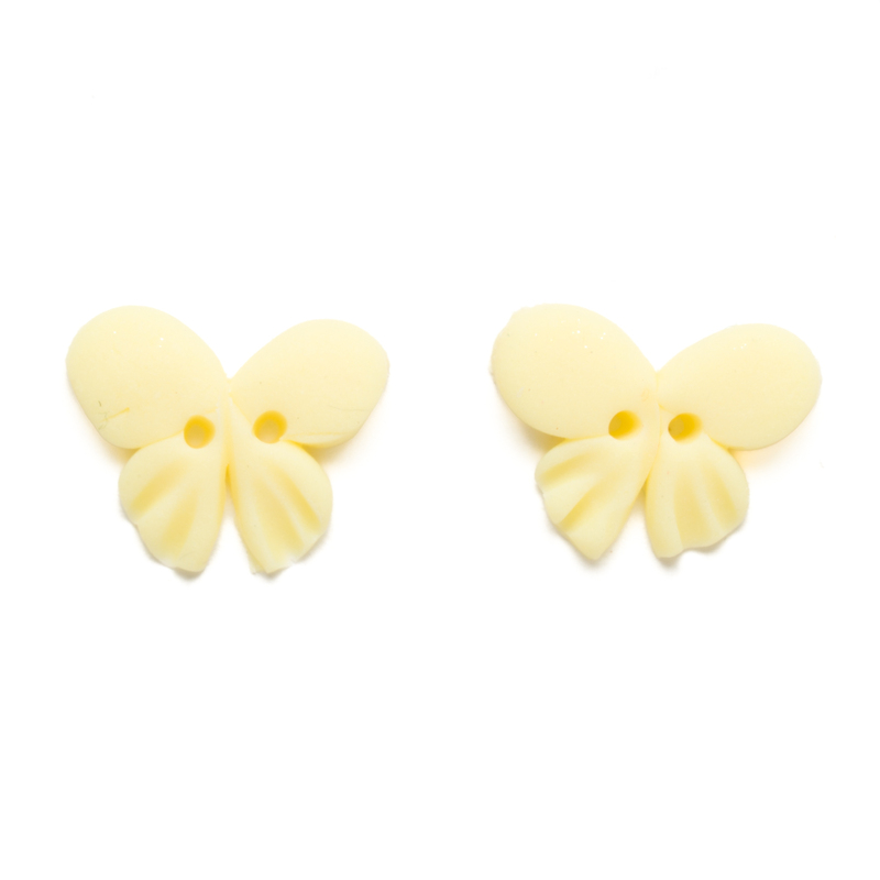 Two pale yellow butterfly clay buttons, isolated on a white background. 