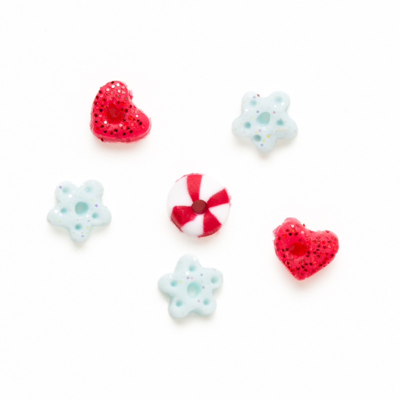 Clay button set of red glitter hearts, blue-white glitter snowflakes, and a peppermint, isolated on a white background. 