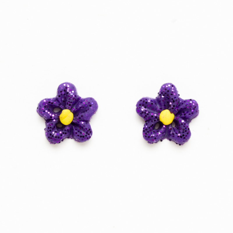 Two small dark purple glitter flower clay buttons with yellow clay centers, isolated on a white background.