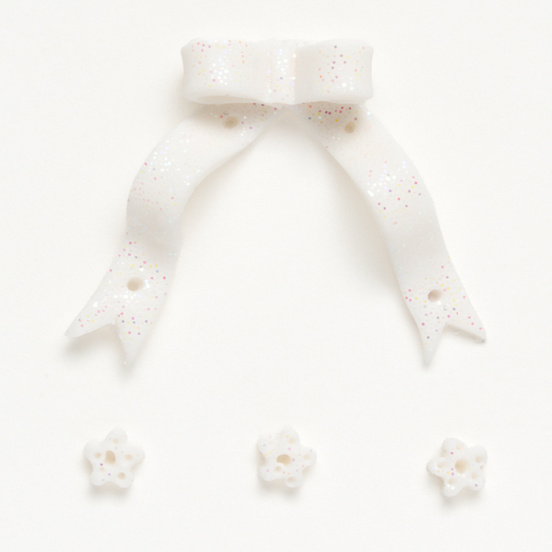 Clay button pack of white ribbon and snowflake charms, isolated on a white background. 