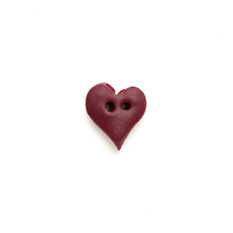 Maroon heart-shaped button on a white background.