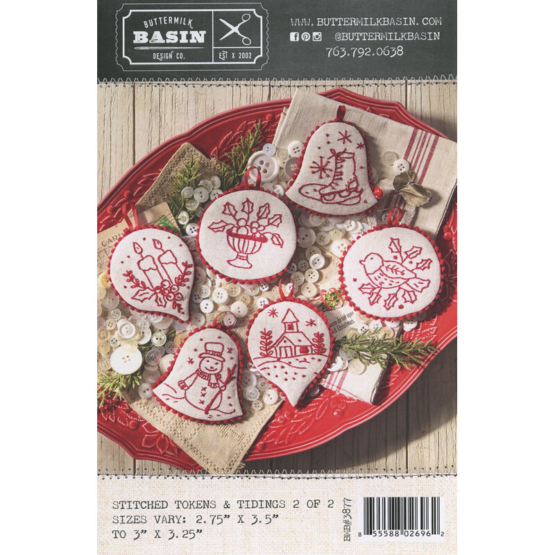 Pattern stitched holiday ornaments on a red tray with a craft pattern label.