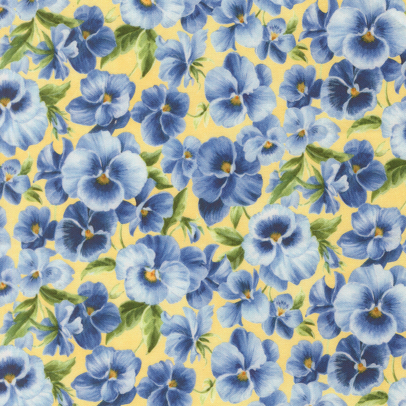 Soft yellow fabric packed with light and dark blue pansies.