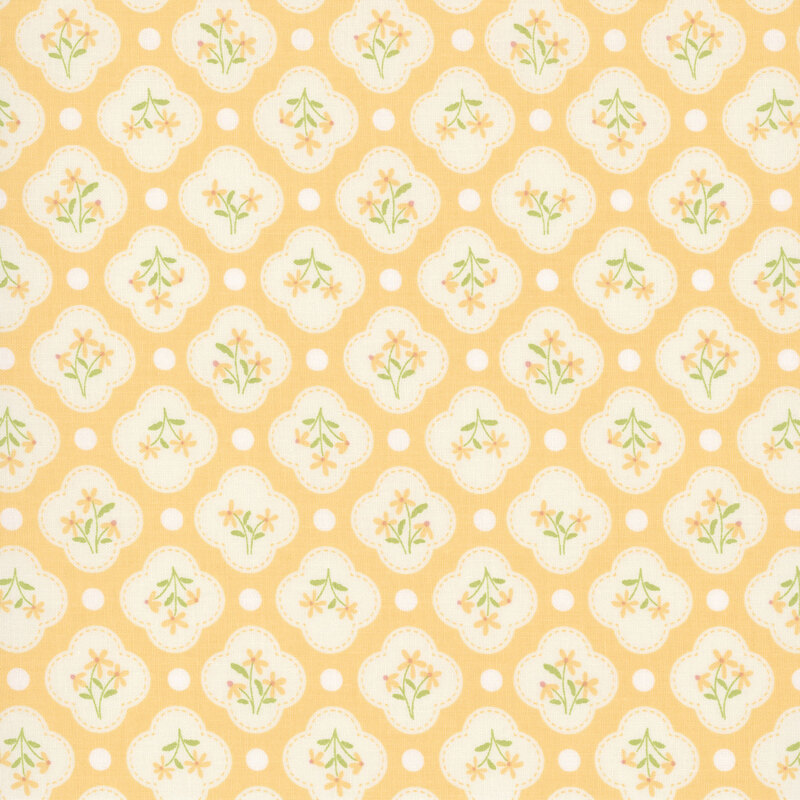 This golden yellow fabric features white quatrefoils amongst white dots. 