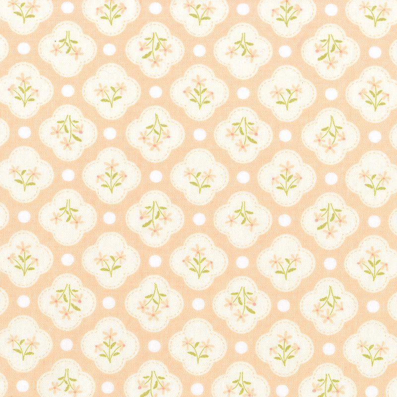 This light coral fabric features white quatrefoils amongst white dots. 