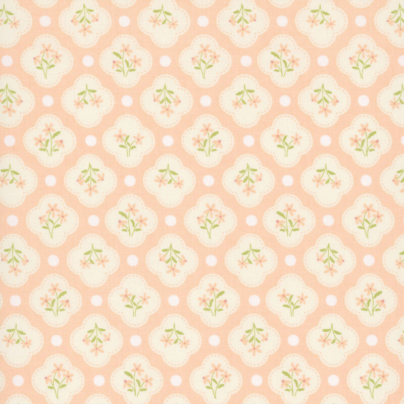 This light coral fabric features white quatrefoils amongst white dots. 