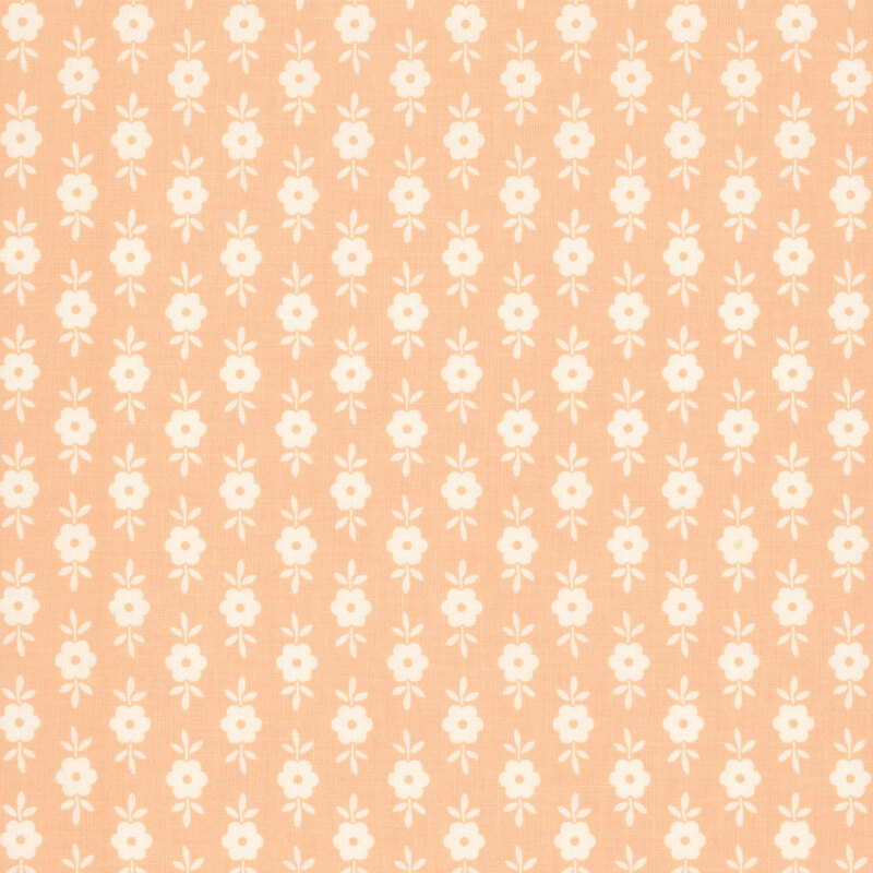 This pastel peach fabric features white floral motifs. 