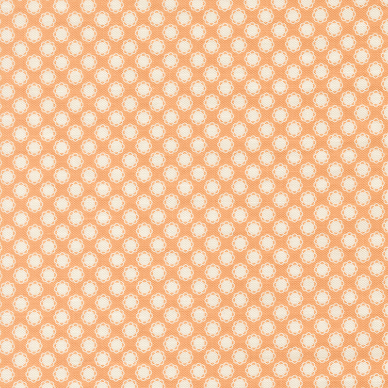 This soft peach fabric features white doily motifs. 