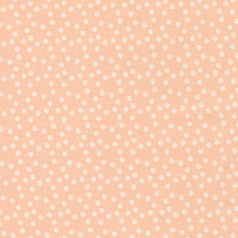 This nude pink ditsy fabric features white florals. 