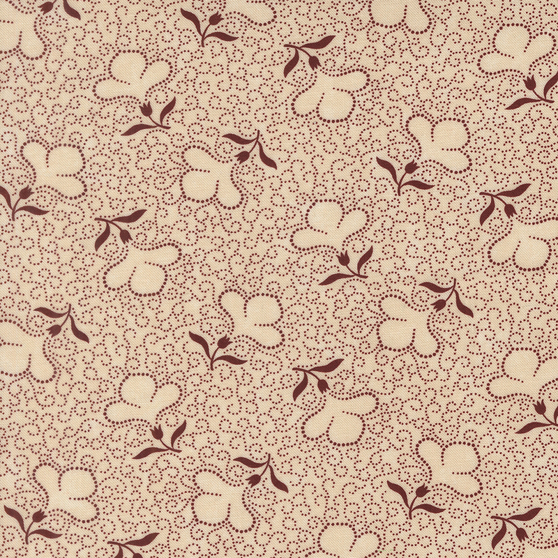 Tan fabric with a packed design of red dotted swirls and tossed dotted florals.