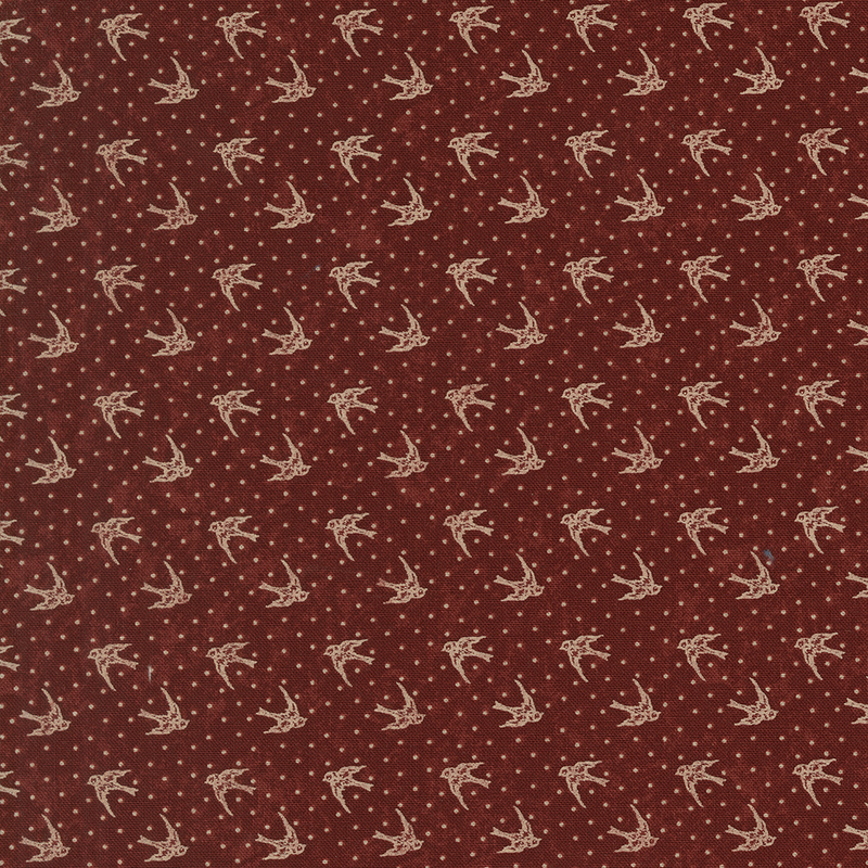 Red fabric with tan dotted background topped with tan cardinals in flight.