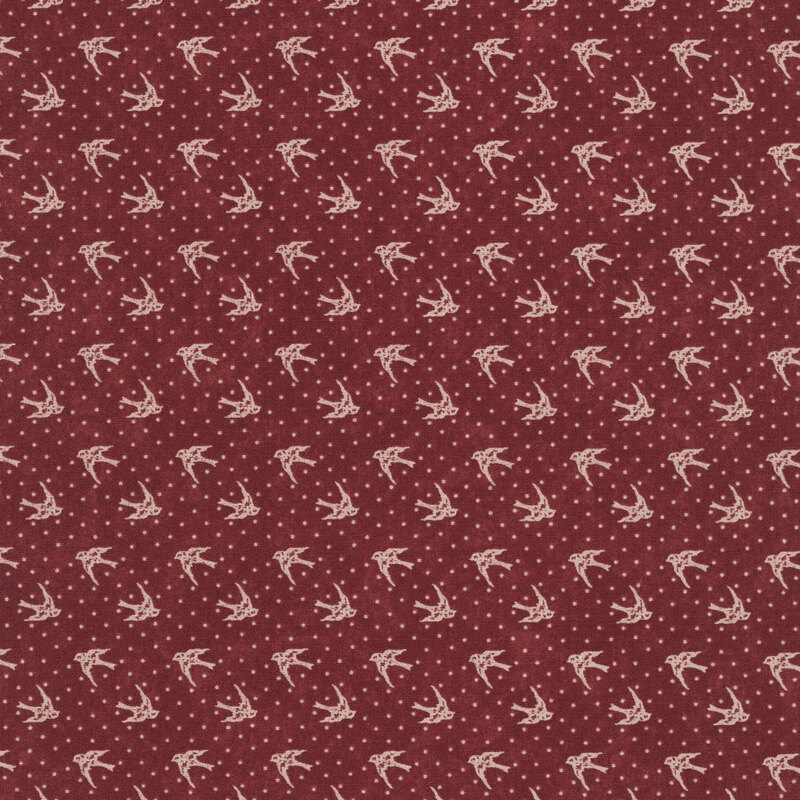 Red fabric with tan dotted background topped with tan cardinals in flight.