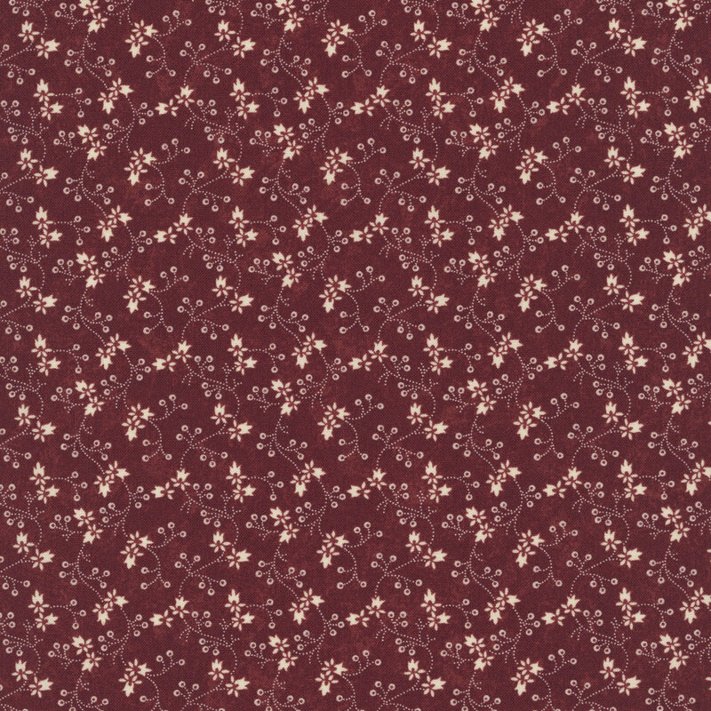 Red fabric with a pattern of vertical tan vines and florals.