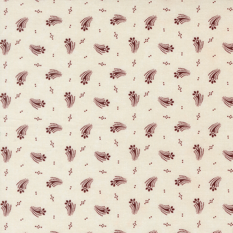 Cream fabric with a tossed design of red dots and abstract red floral motifs.