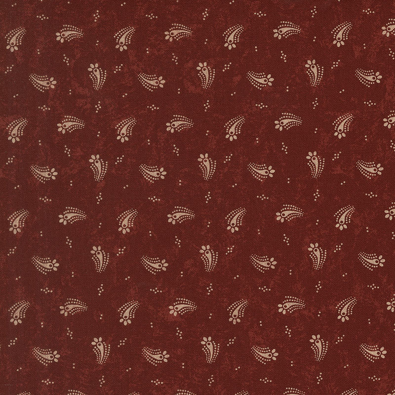 Red fabric with a tossed design of tan dots and abstract tan floral motifs.