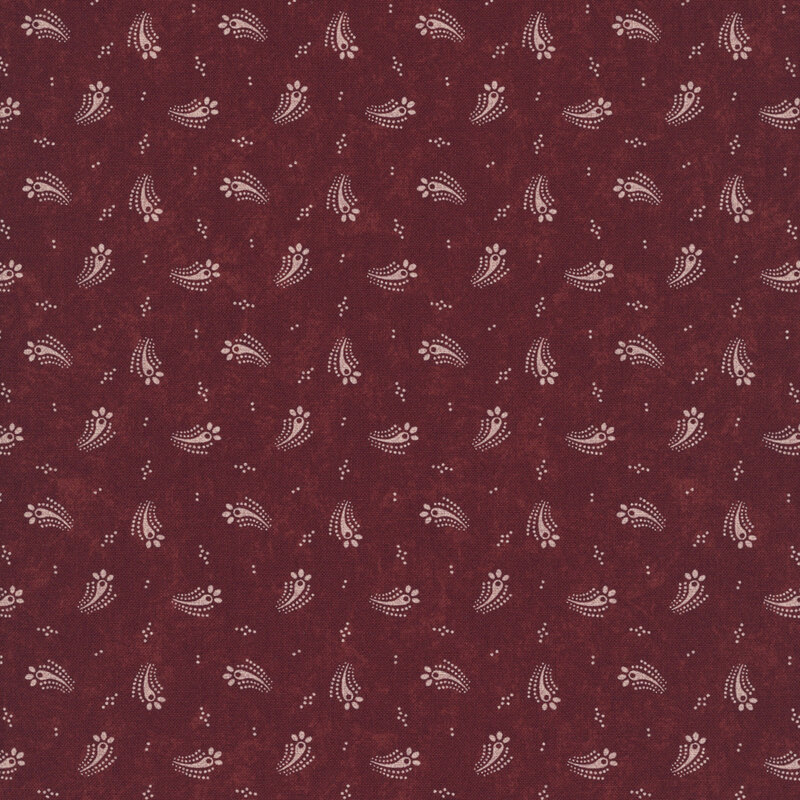 Red fabric with a tossed design of tan dots and abstract tan floral motifs.