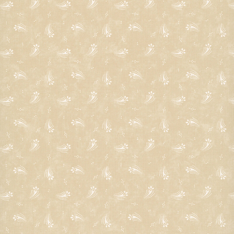 Tan fabric with a tossed design of cream dots and abstract cream floral motifs.