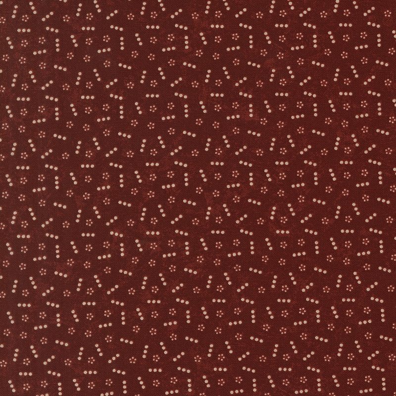 Red fabric topped with a scattered pattern of lines and groups of small tan dots.