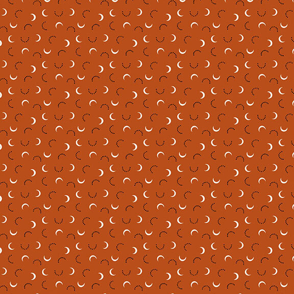 A burnt sienna fabric with white crescents and black doted half-circles.