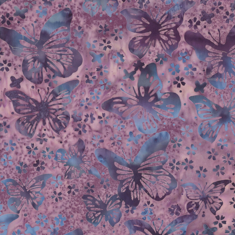 dusty mauve batik fabric featuring mottled butterflies with stylized floral blossoms and dots in shades of dark violet and grey blue.