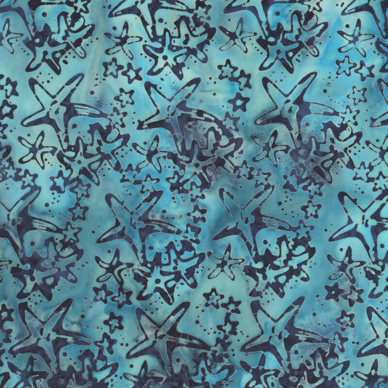 A mottled aqua batik fabric featuring navy starfish and smaller sea stars.