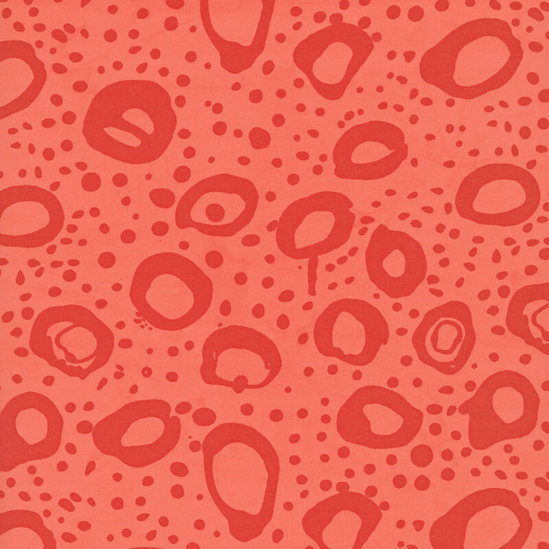 Bright light orange fabric with irregular stamped circles and dots in tonal dark red orange.