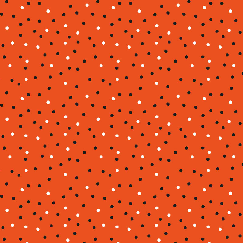 A bright orange fabric with scattered white and black dots. 