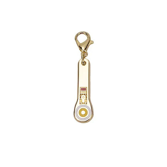 Gold enamel charm featuring a gold, decorative enamel rotary cutter with a lobster claw clasp isolated on a white background.