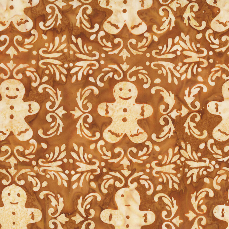 This gingersnap brown batik fabric features cream motifs of gingerbread men framed by swirling borders. 