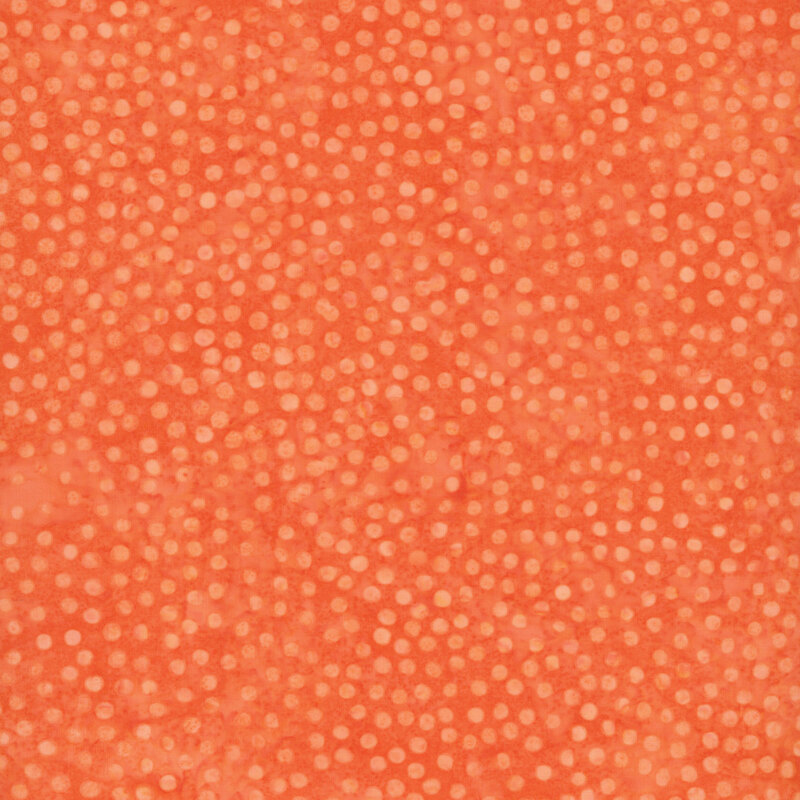 Pumpkin orange batik with a scattered pattern of small, peach-orange dots. 