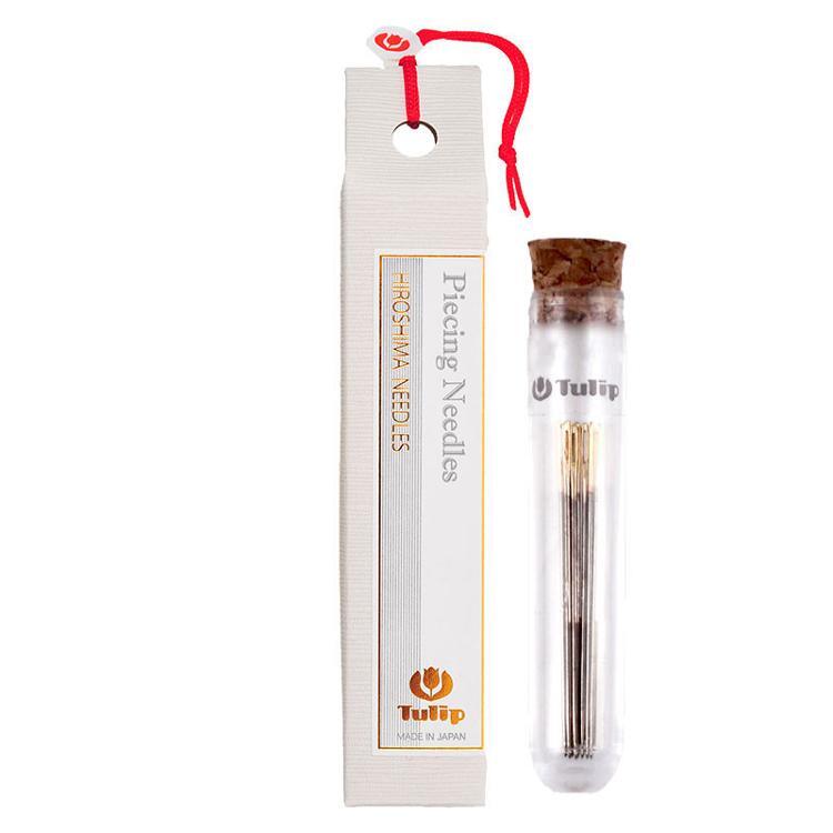6 piece set of #9 Tulip piecing needles in a thin container next to a white carton package.