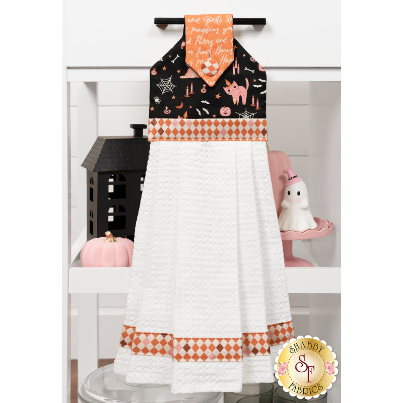 The completed Hanging Towel colored in Halloween fabrics from the Purrs & Boos collection by Moda Fabrics, staged on a kitchen drawer with coordinating decor.