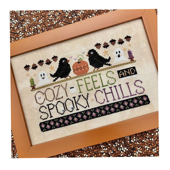 The completed WordyBirds - October cross stitch project framed and staged on a fall printed backdrop.