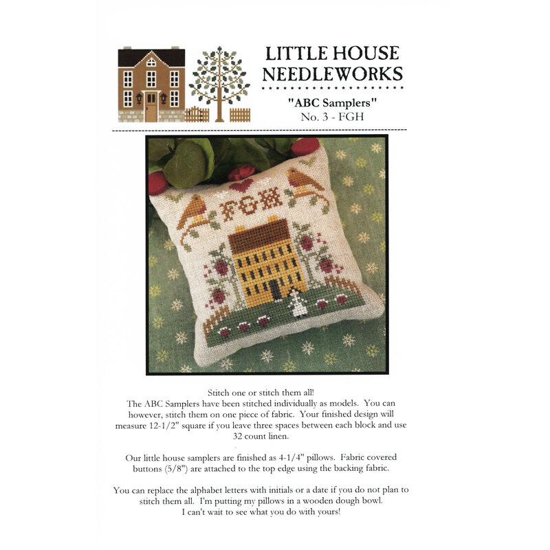 Front of pattern showing the completed cross stitch on a small ornament pillow staged on a floral fabric.