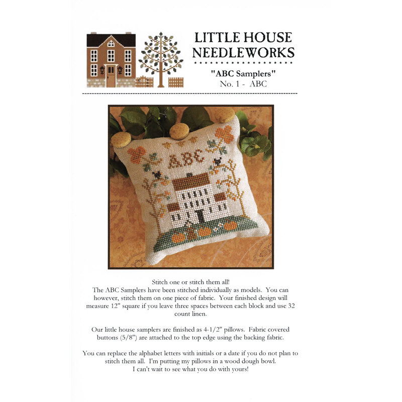 Front of pattern showing the completed cross stitch on a small ornament pillow staged on a floral fabric.