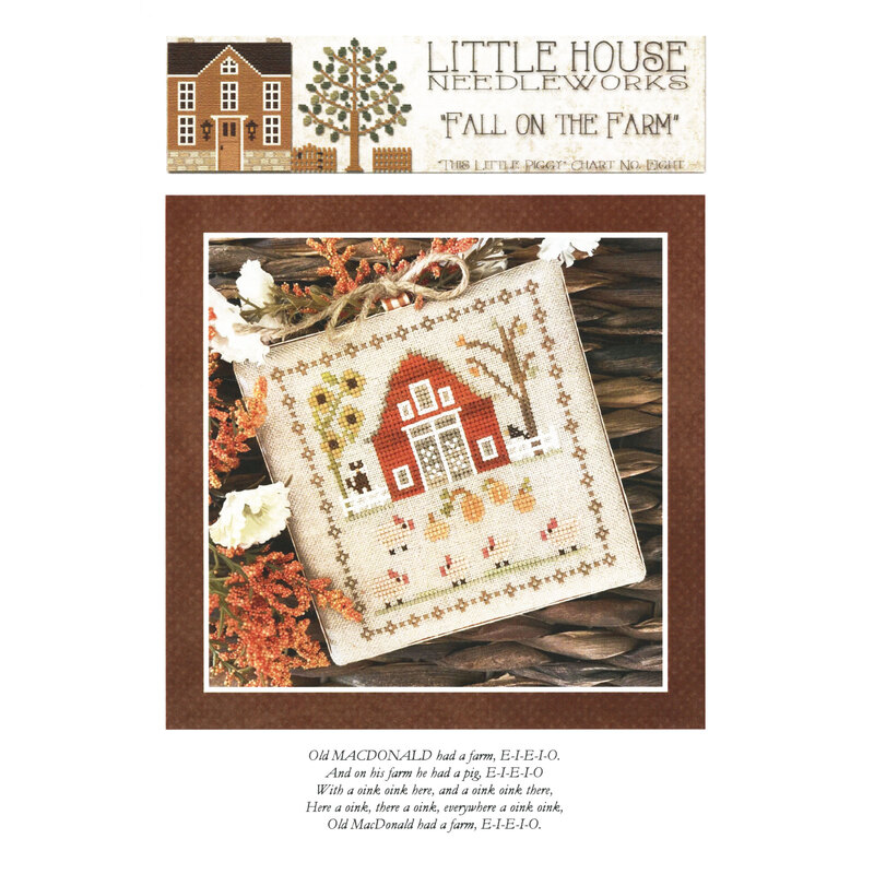 Front of pattern showing the completed cross stitch on a small ornament pillow staged on a table by autumnal sprigs.