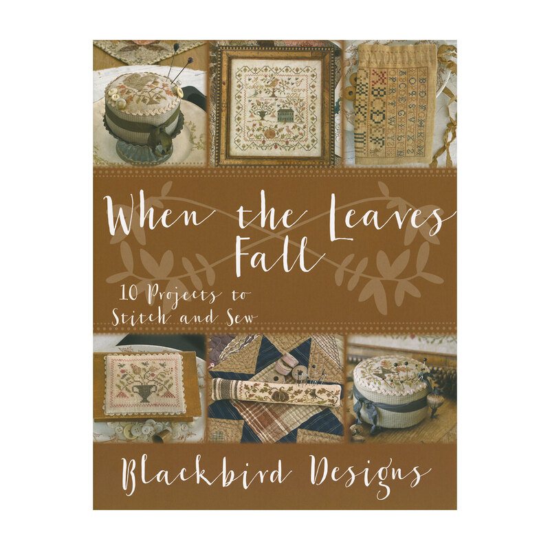 Front cover of the When the Leaves Fall cross stitch book, with six of the the finished patterns laid on a brown background.