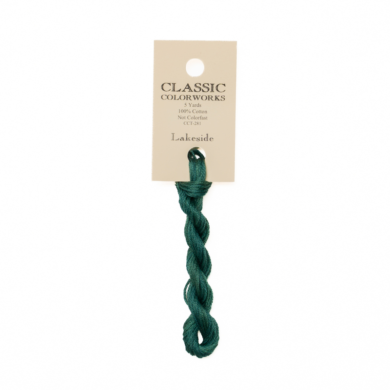 A skein of teal green embroidery floss, twisted and bundled, with a cream and black label featuring the brand name and color information.