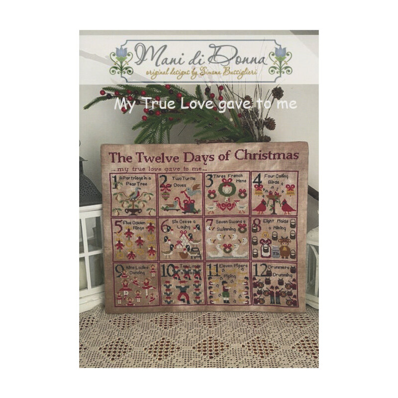 Front cover of the My True Love Gave to Me cross stitch pattern with the pattern on top of a decorative mat.
