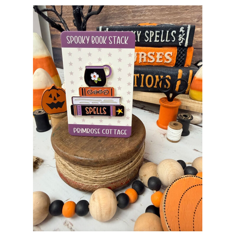 The spooky book stack needle minder in its packaging, isolated on a white background.