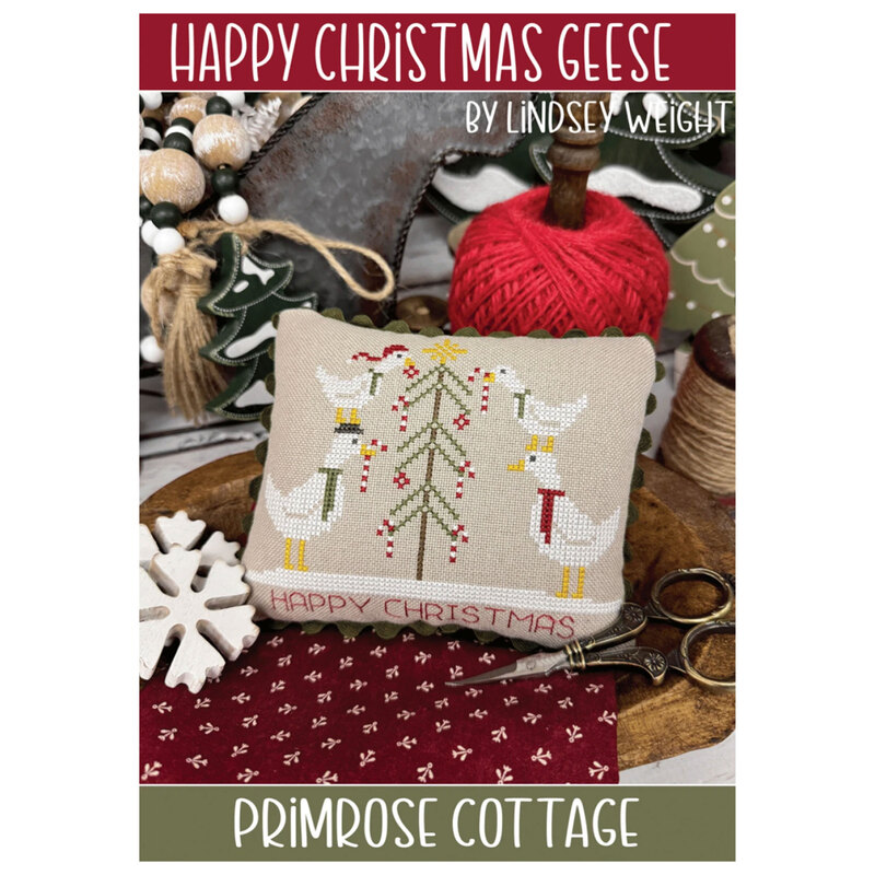 Front of the Happy Christmas Geese cross stitch pattern staged with seasonal accents and décor. 