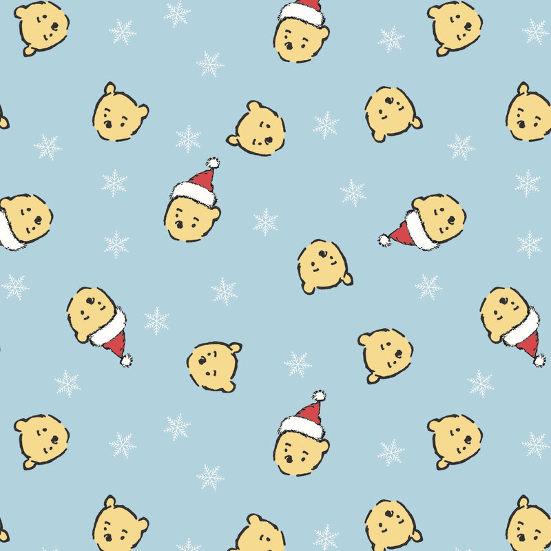 Powder blue fabric with a tossed design of white snowflakes and Pooh Bear heads wearing Santa hats.