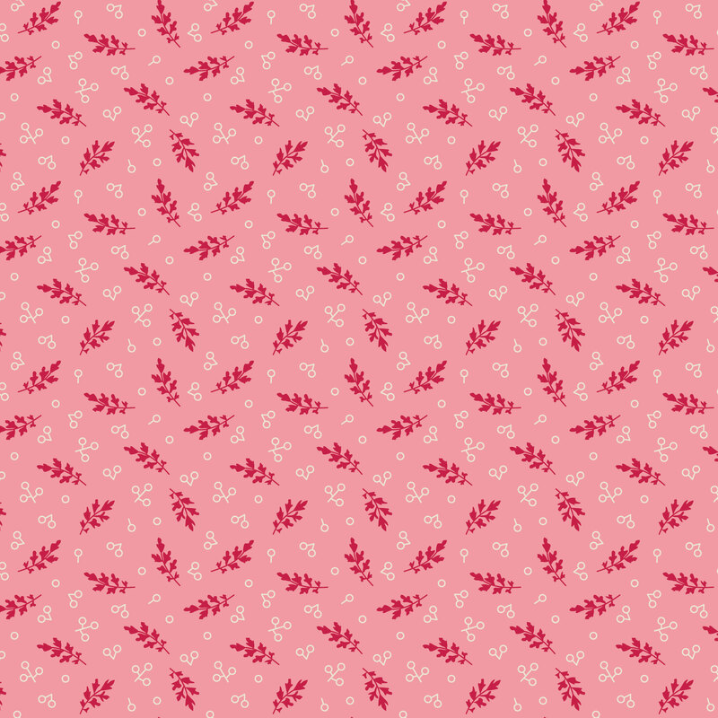 Pink fabric with a scattered pattern of red leaves and white circles.