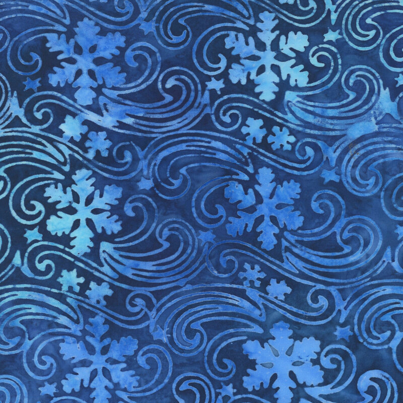 Mottled indigo blue batik fabric with a pattern of snowflakes drifting in the wind.