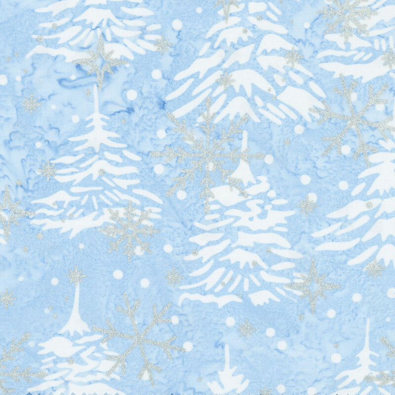 Mottled light blue batik fabric with a tossed pattern of pine trees accented with scattered metallic winter motifs.