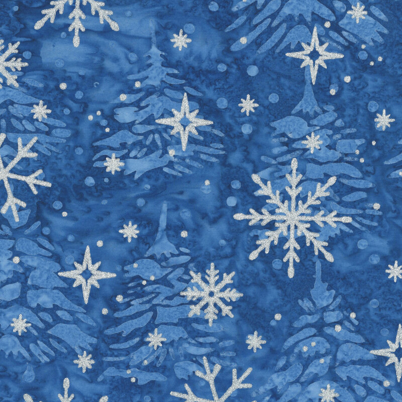 Mottled blue batik fabric with a tossed pattern of pine trees accented with scattered metallic winter motifs.