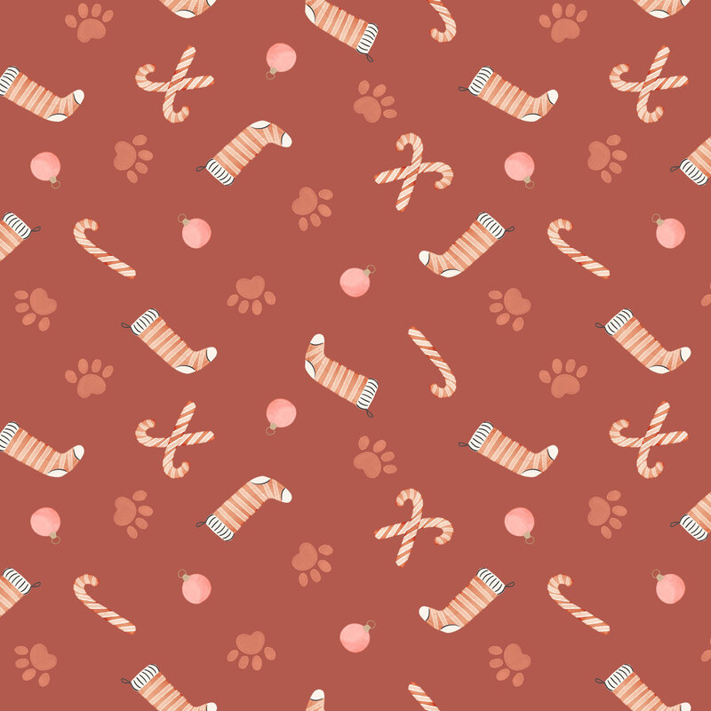 Terra cotta fabric with a tossed pattern of light red paw prints, candy canes, stockings, and ornaments.