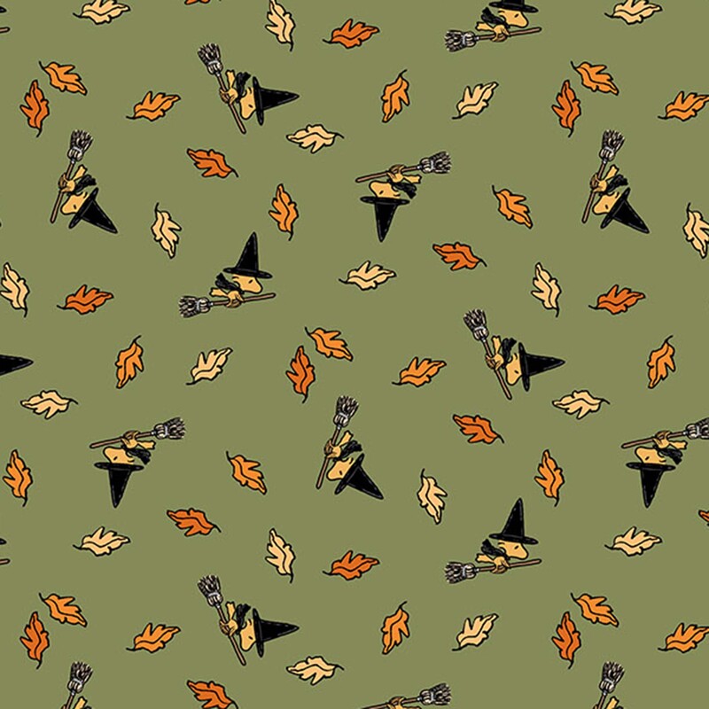A warm sage green fabric with Woodstock in a witch costume on a flying broom among scattered falling autumn leaves. 