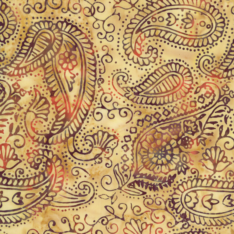 batik fabric featuring intricate paisley motifs, swirling vines, and delicate floral accents in shades of plum, rust, and warm brown against a softly mottled tawny yellow background.